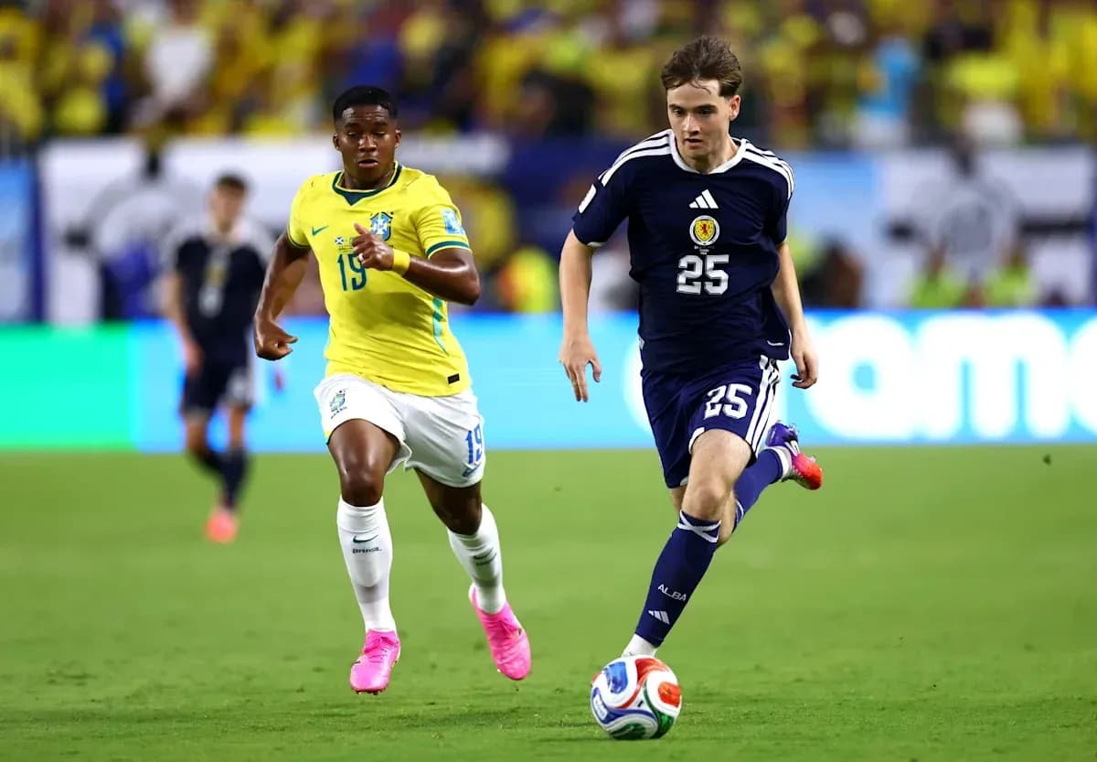 Jugador de Escocia corriendo con balón, seguido por brasileño