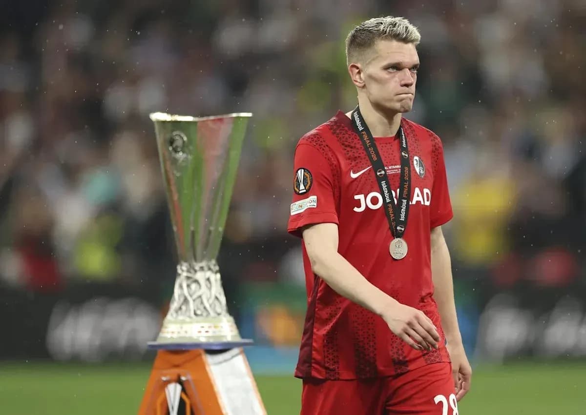 Jugador con medalla caminando junto a trofeo de Europa League