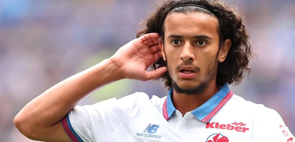 Jugador con cabello rizado escuchando durante el partido