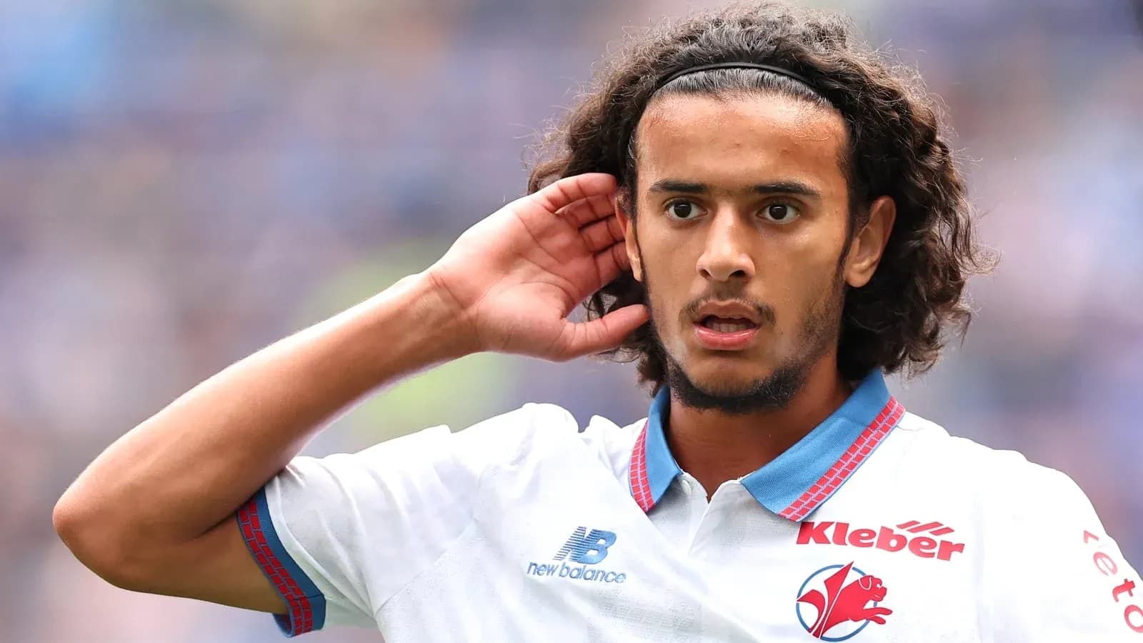 Jugador con cabello rizado escuchando durante el partido