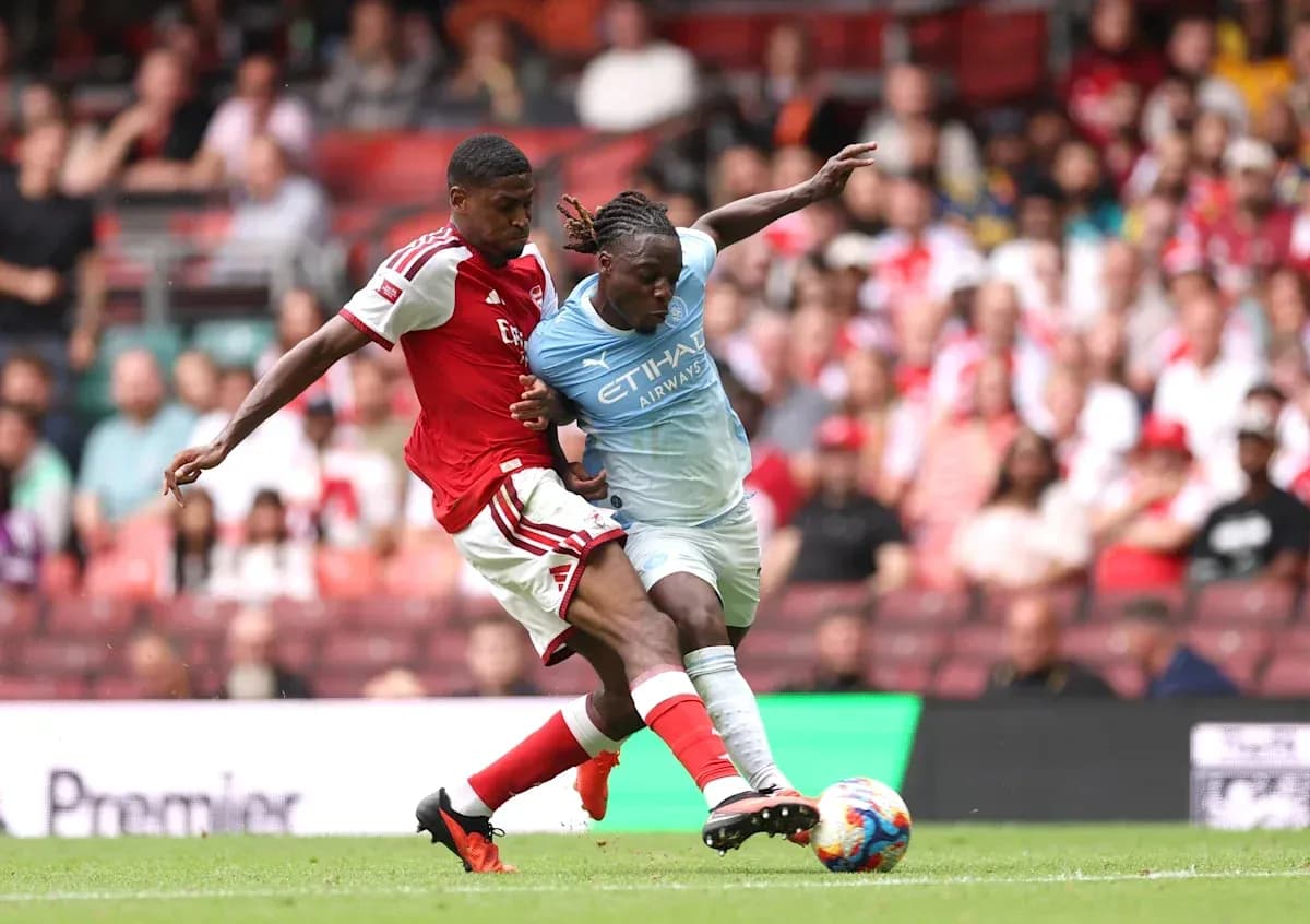 Jugadores de Arsenal y Manchester City luchando por el balón