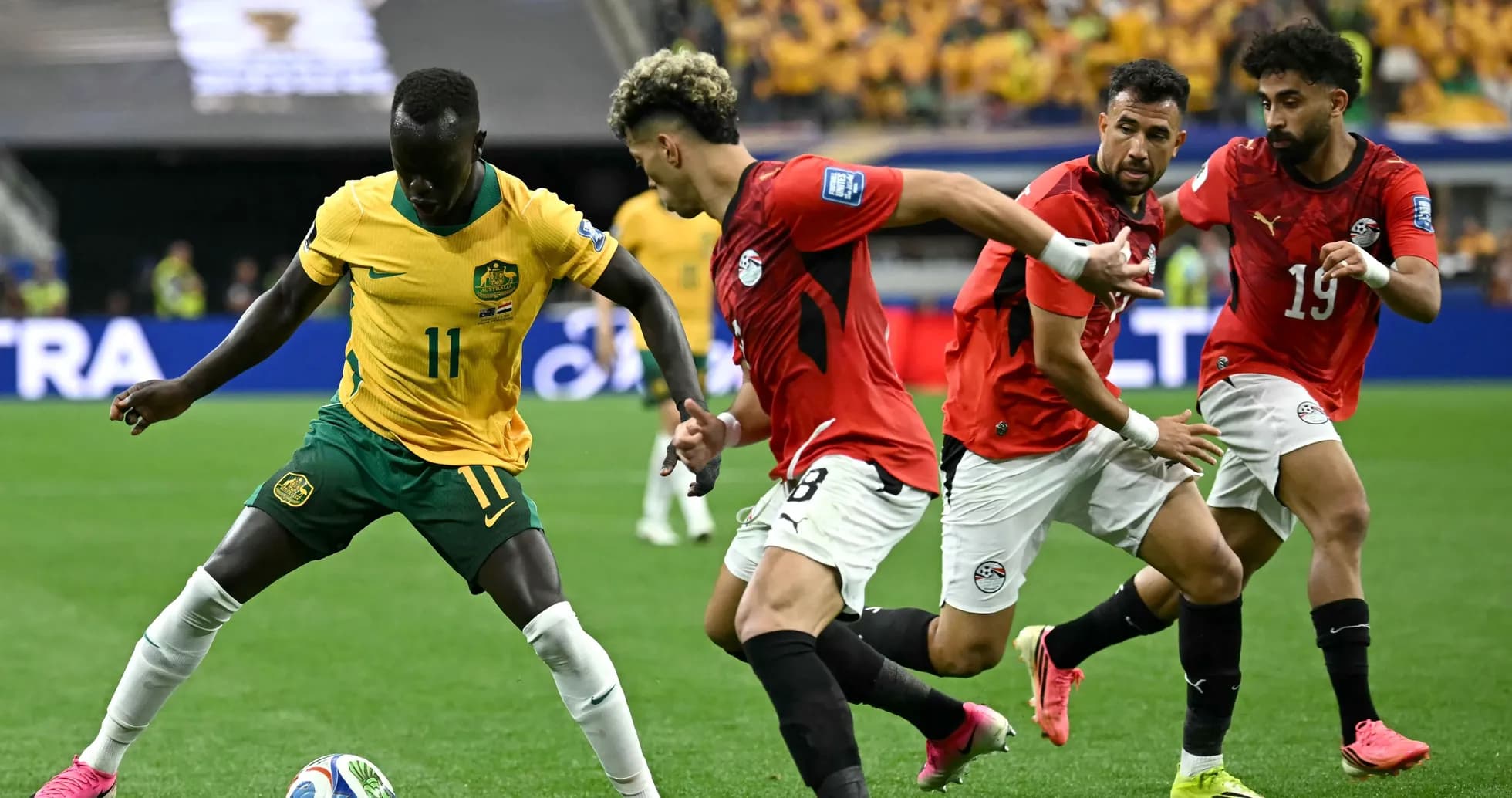 Jugador de Australia driblando entre defensores egipcios