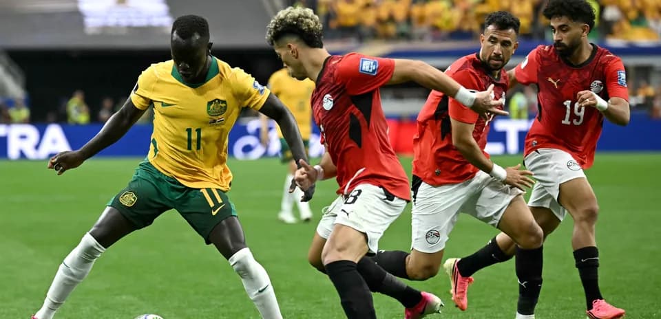 Jugador de Australia driblando entre defensores egipcios