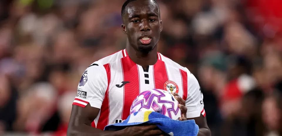 Jugador sosteniendo un balón y toalla en el campo