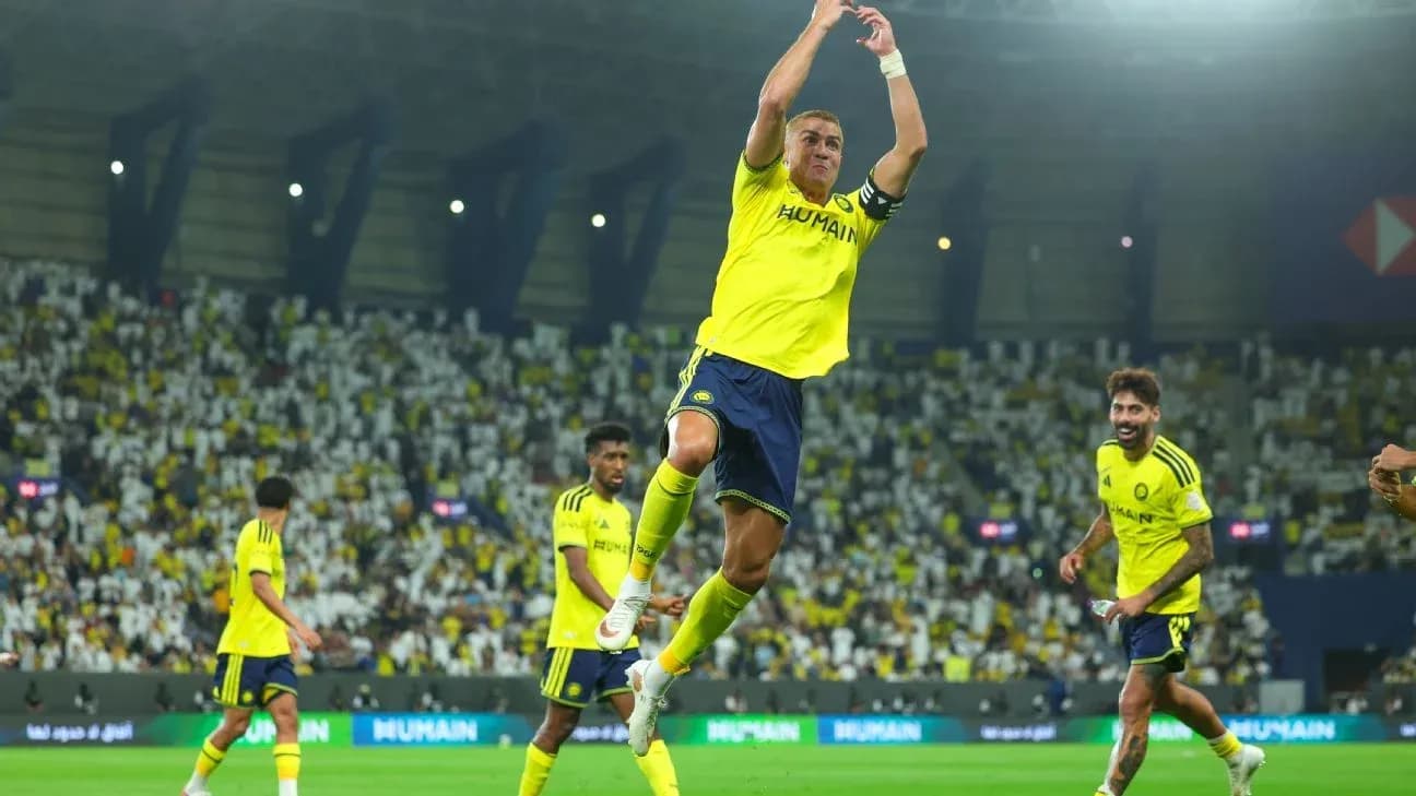 Jugador saltando en celebración con equipo detrás
