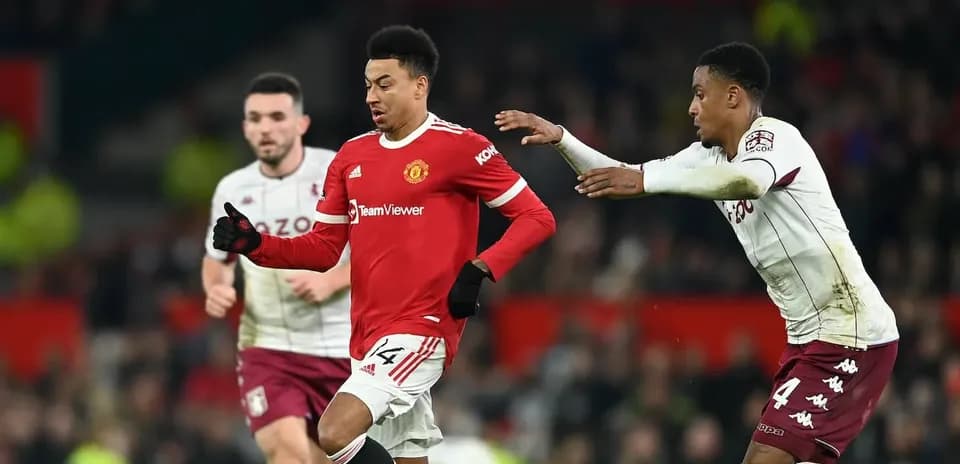 Jugador de Manchester United esquivando a rival de Aston Villa
