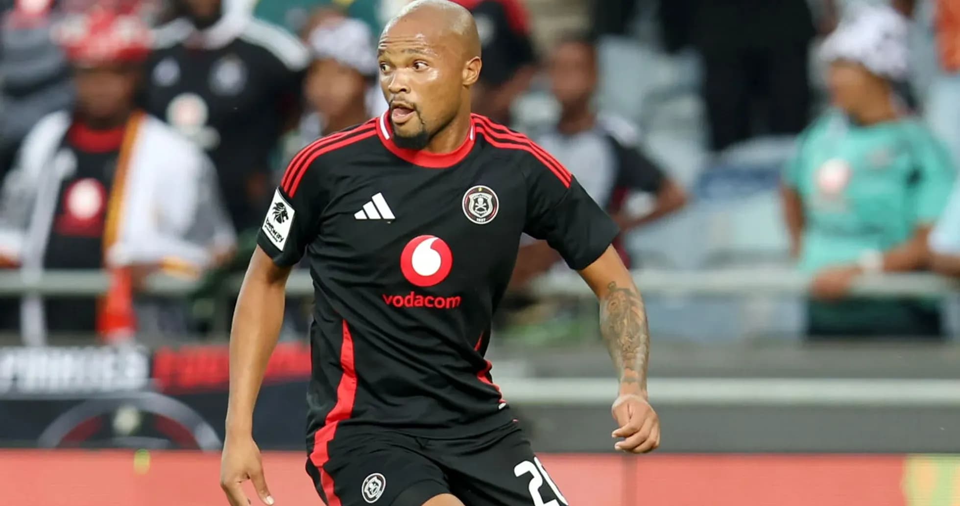 Jugador de Orlando Pirates corriendo con balón en el campo