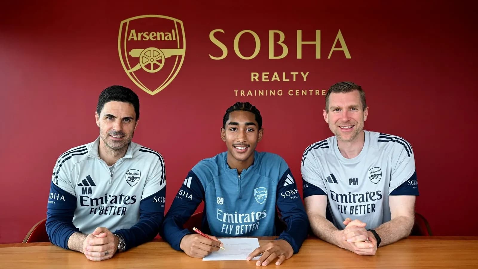 Jugador firmando contrato con el Arsenal en la sede