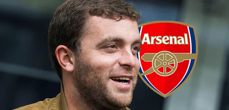 Persona sonriendo con el escudo del Arsenal de fondo