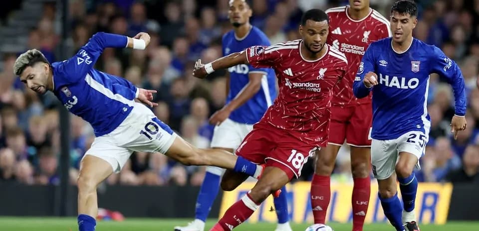 Jugador de Ipswich intentando superar a defensor de Liverpool