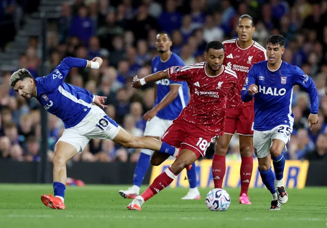 Jugador de Ipswich intentando superar a defensor de Liverpool
