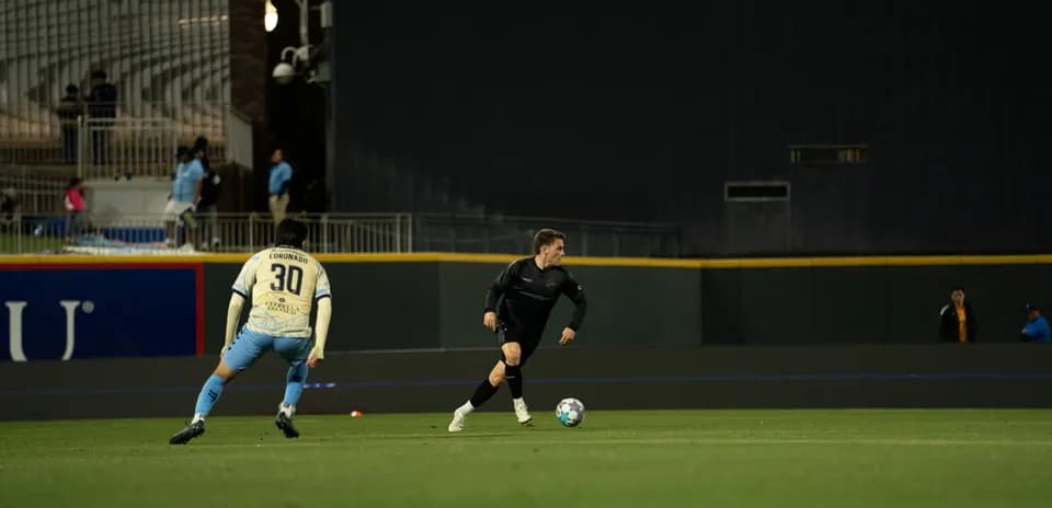 Jugador corriendo con balón en el partido