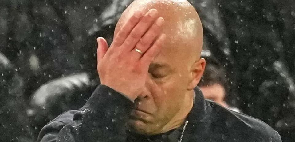 Entrenador con la mano en la frente durante partido