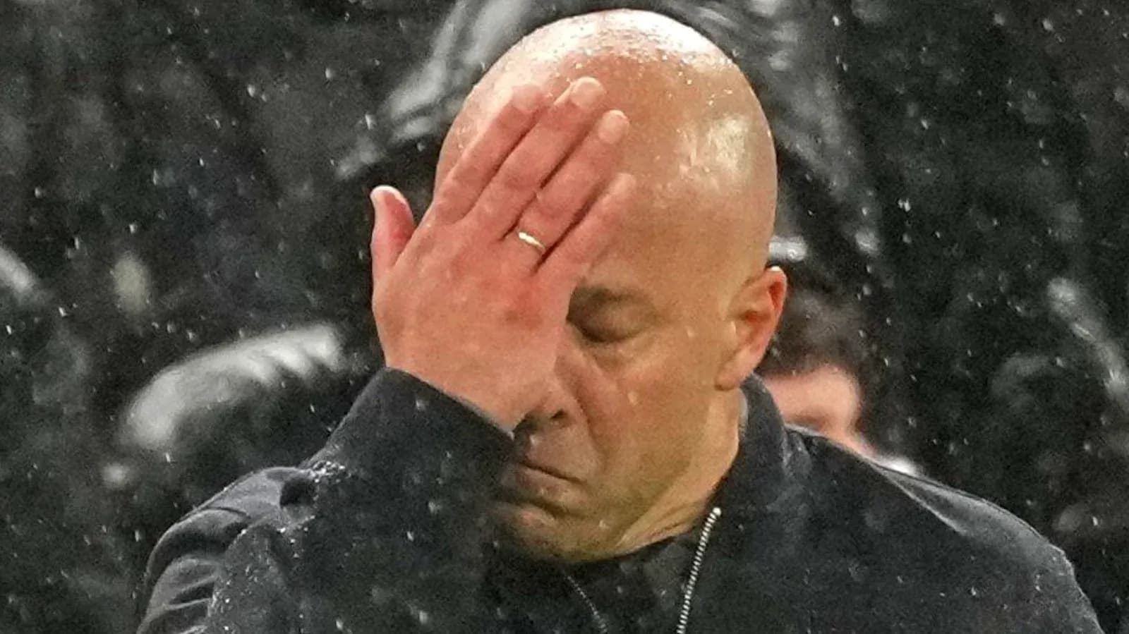 Entrenador con la mano en la frente durante partido