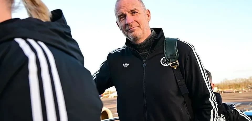 Entrenador con chaqueta negra en aeropuerto