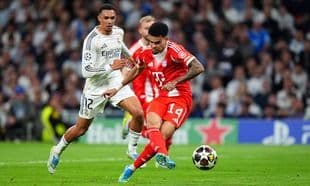 Jugador de Bayern München esquivando a defensor de Real Madrid