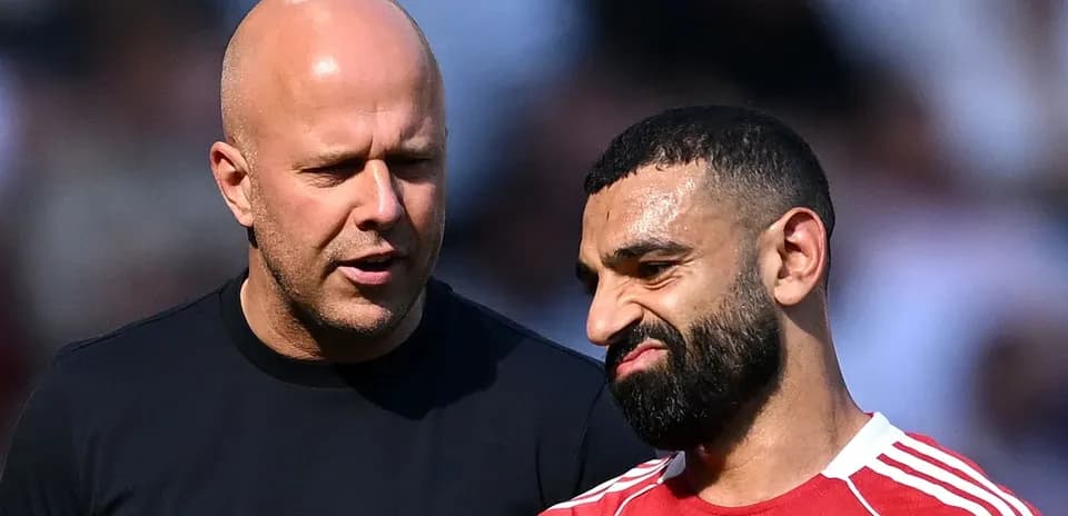 Dos hombres conversando en un campo de fútbol