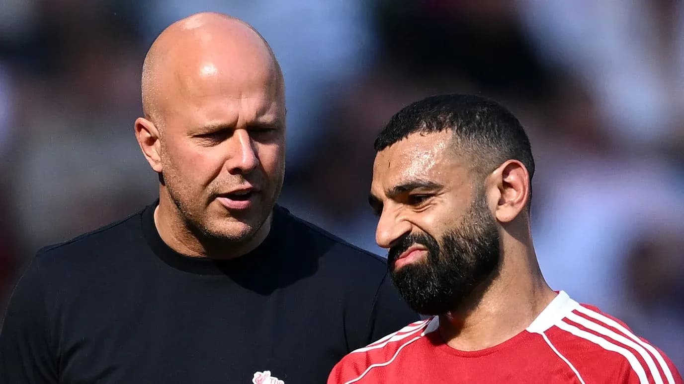 Dos hombres conversando en un campo de fútbol