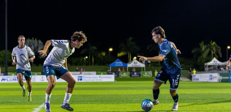Jugadores de fútbol en partido nocturno