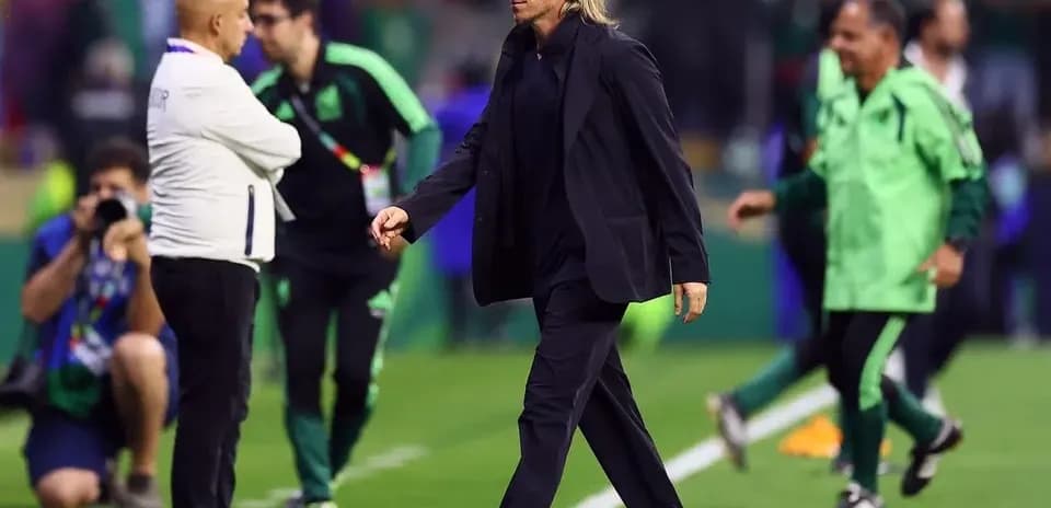 Entrenador caminando por el campo durante el partido