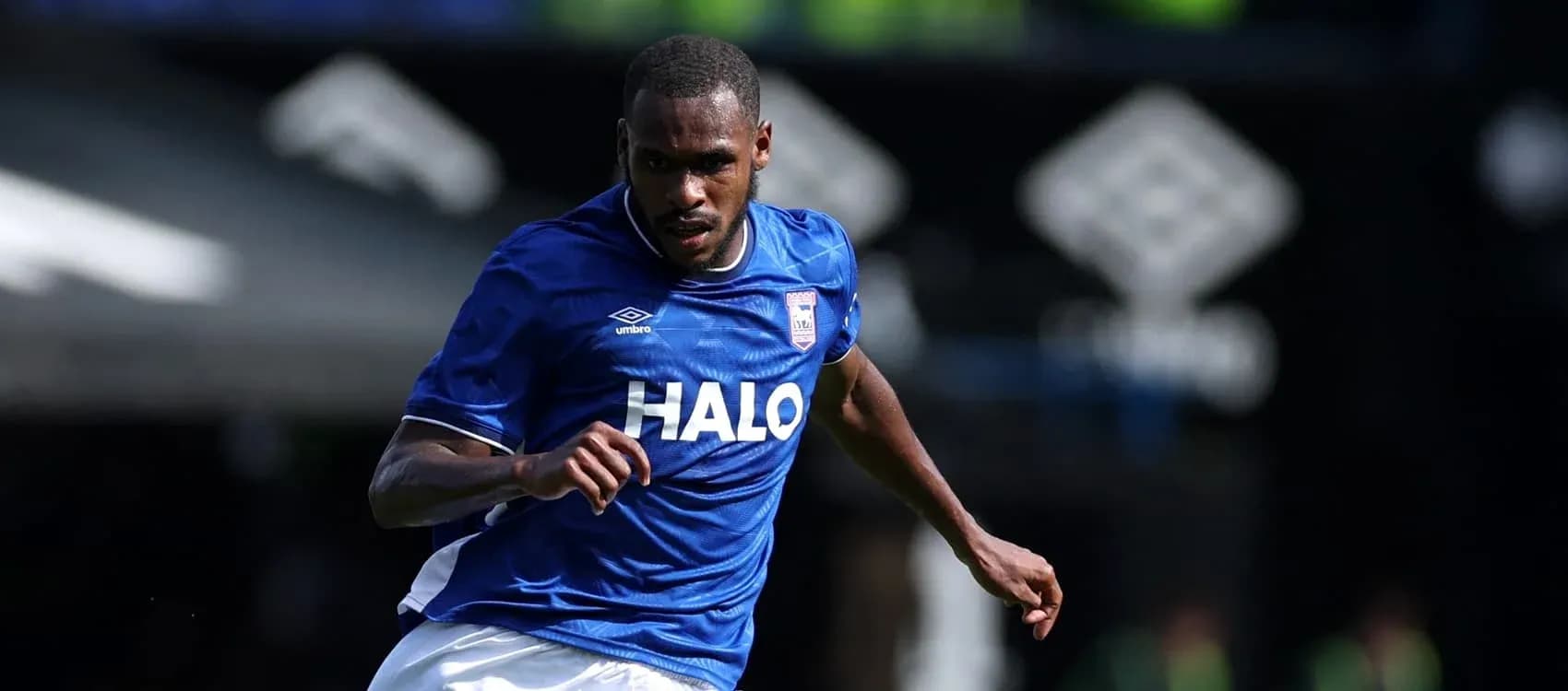 Jugador de Ipswich Town corriendo con balón en el campo