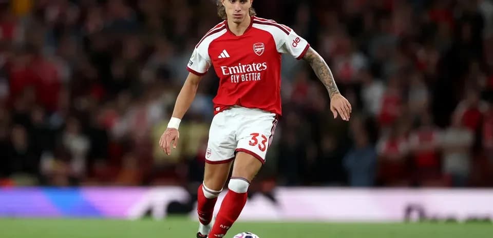 Jugador del Arsenal conduciendo el balón en el campo