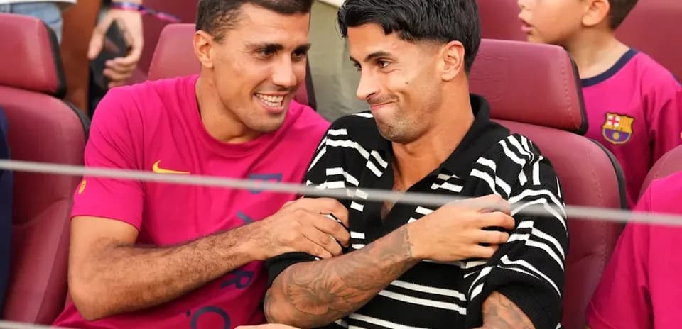 Dos jugadores conversando en asientos del estadio