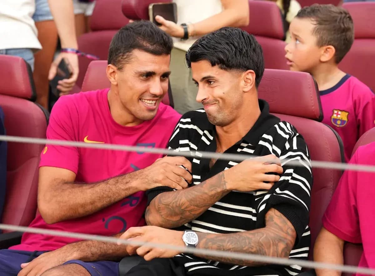 Dos jugadores conversando en asientos del estadio