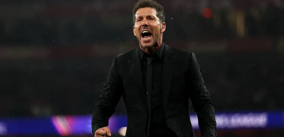 Entrenador celebrando durante un partido bajo la lluvia