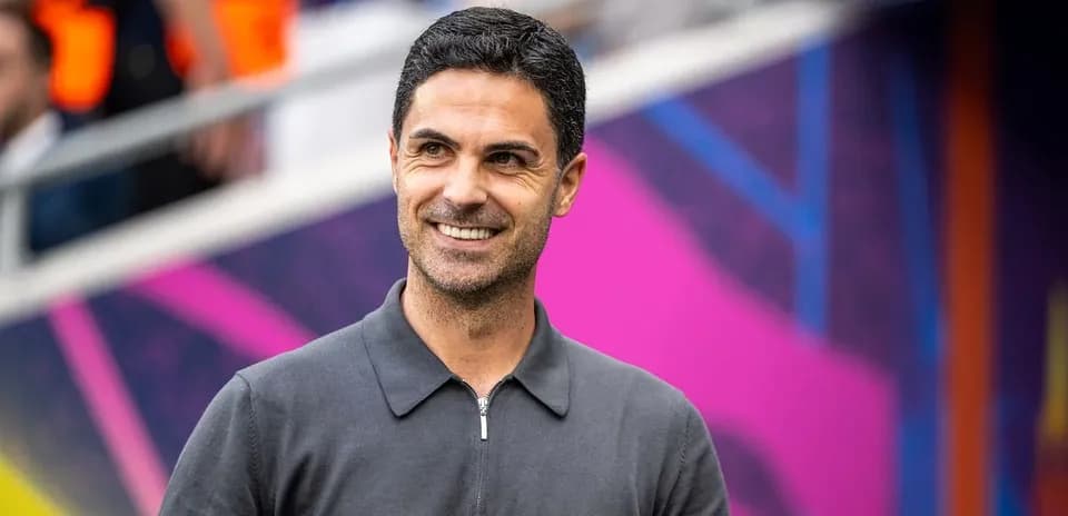 Entrenador sonriendo en el banquillo del estadio