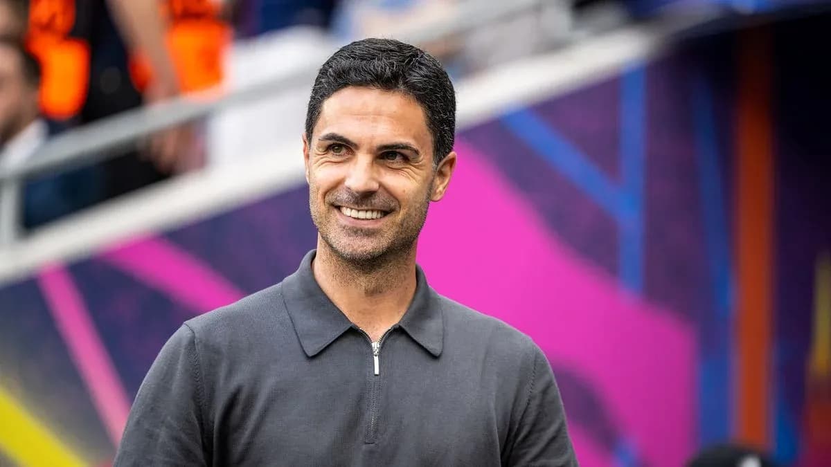 Entrenador sonriendo en el banquillo del estadio