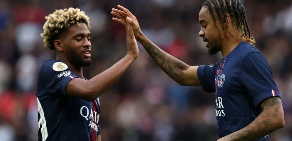 Dos jugadores de PSG chocando las manos en el campo