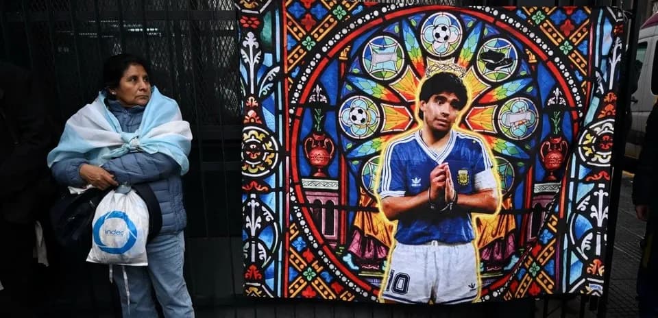 Mujer con abrigo y bufanda argentina junto a mural