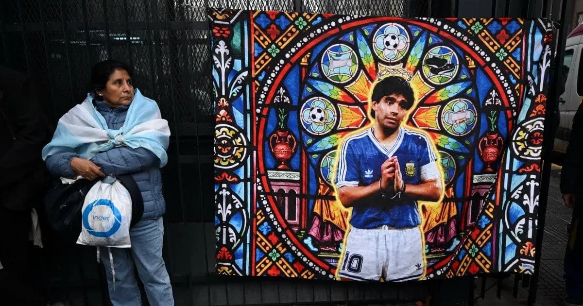 Mujer con abrigo y bufanda argentina junto a mural