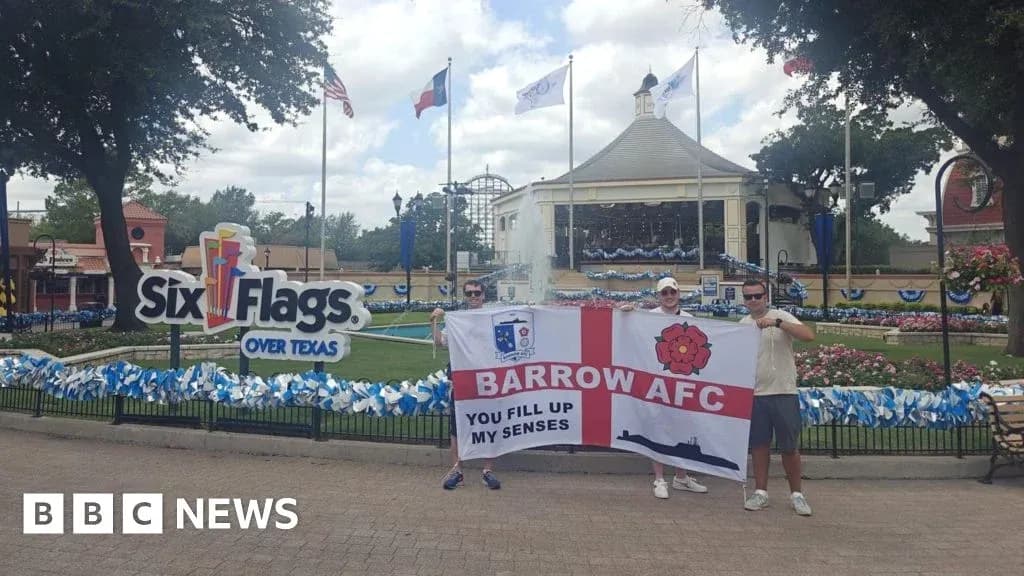 Dos personas sosteniendo una bandera de Barrow AFC en Six Flags