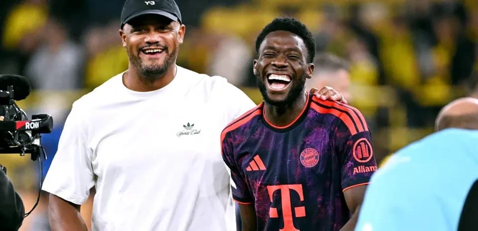 Dos hombres sonriendo en el campo de fútbol