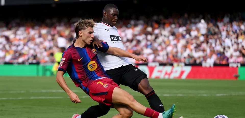 Jugador de Barcelona en acción defensiva contra rival