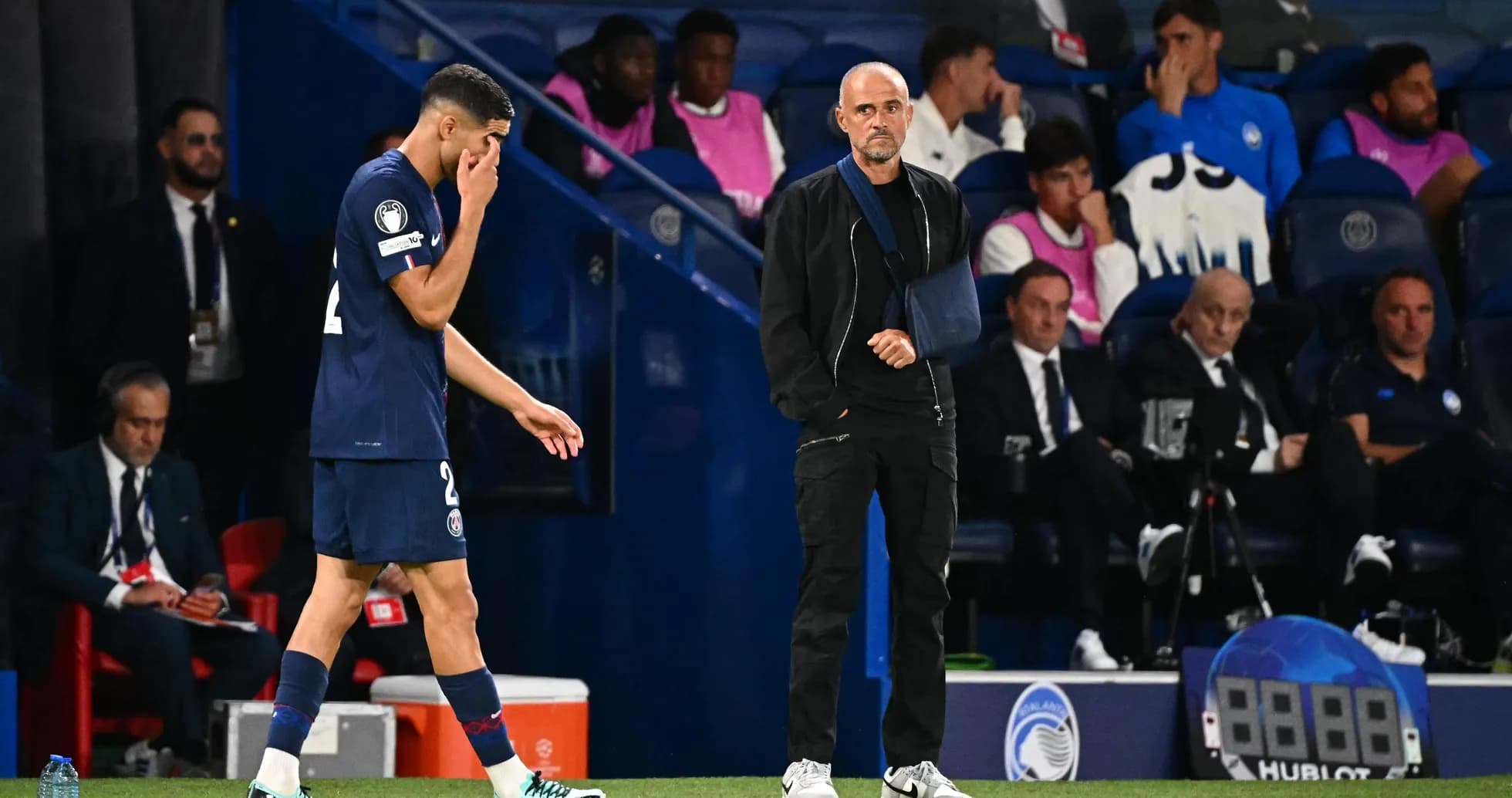 Jugador de PSG saliendo del campo, entrenador observando