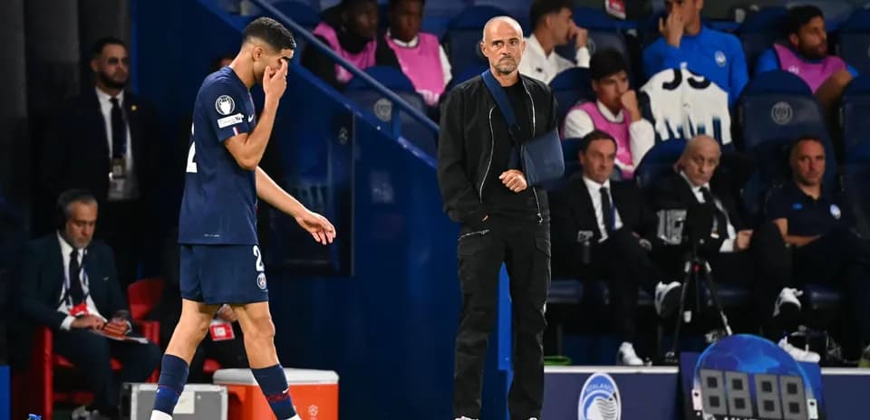 Jugador de PSG saliendo del campo, entrenador observando