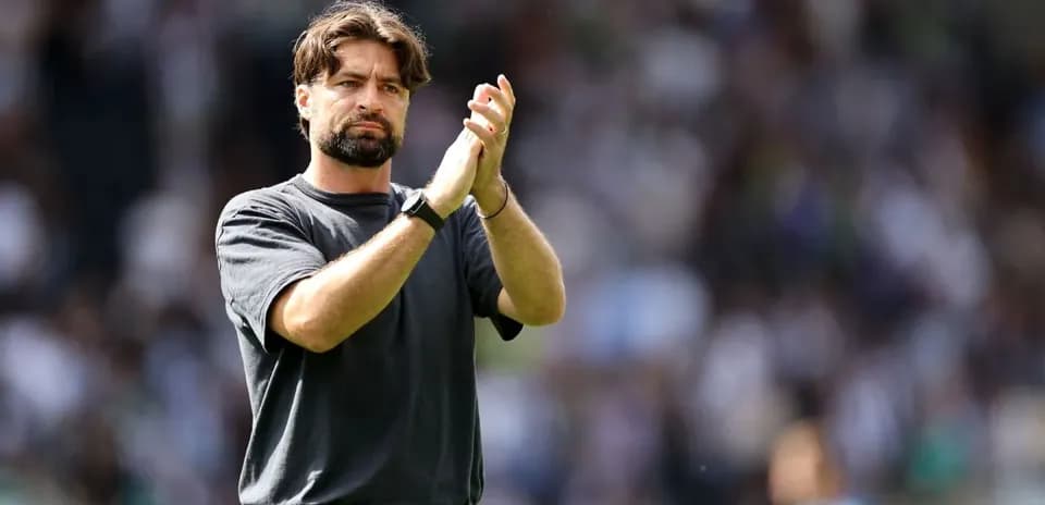 Entrenador aplaudiendo en el estadio durante el partido