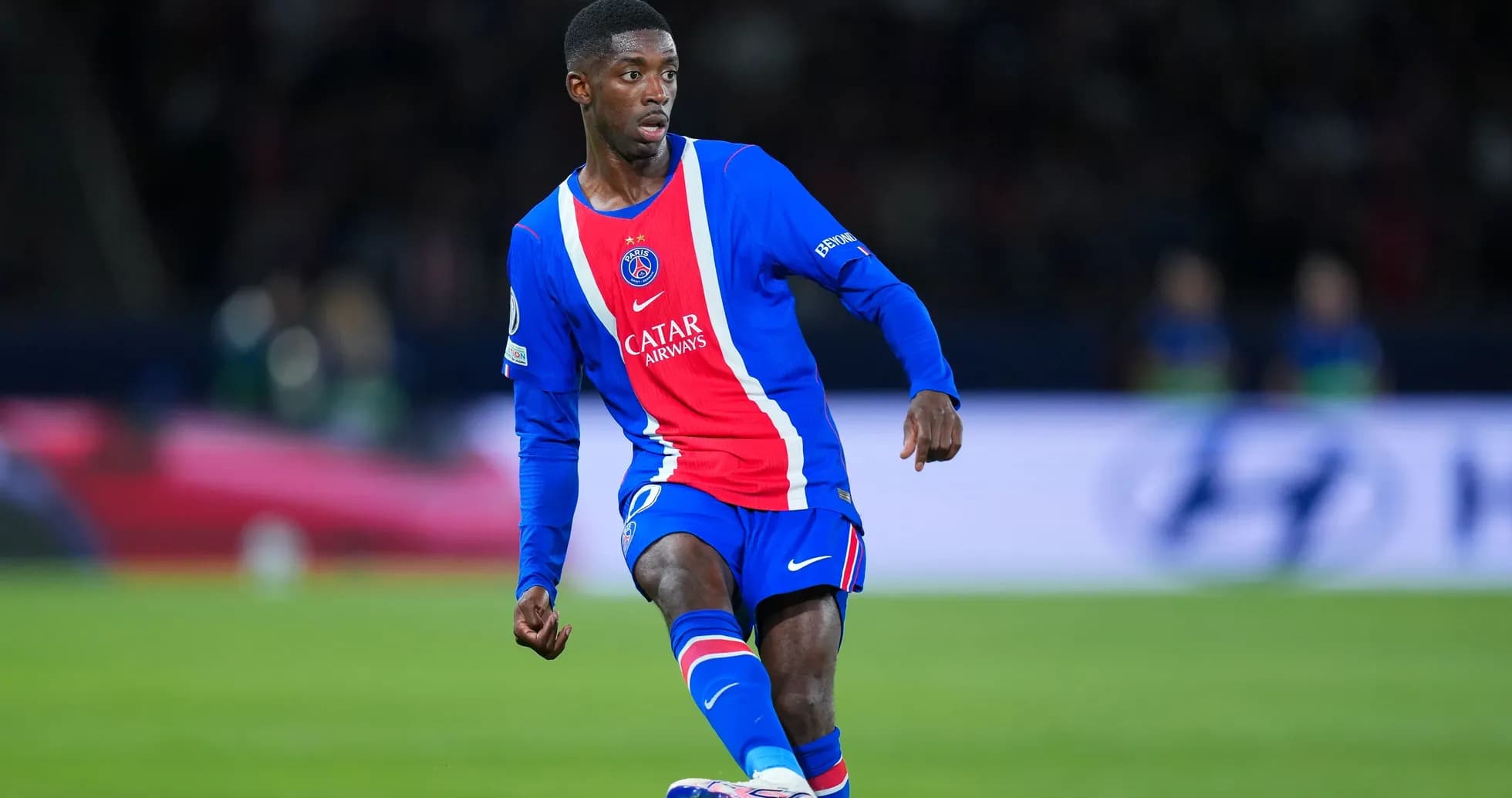 Jugador de PSG corriendo con el balón en el campo