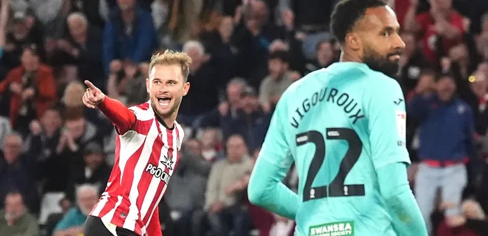 Jugador celebrando gol mientras el portero observa