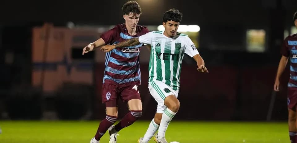 Dos jugadores compitiendo por el balón en fútbol