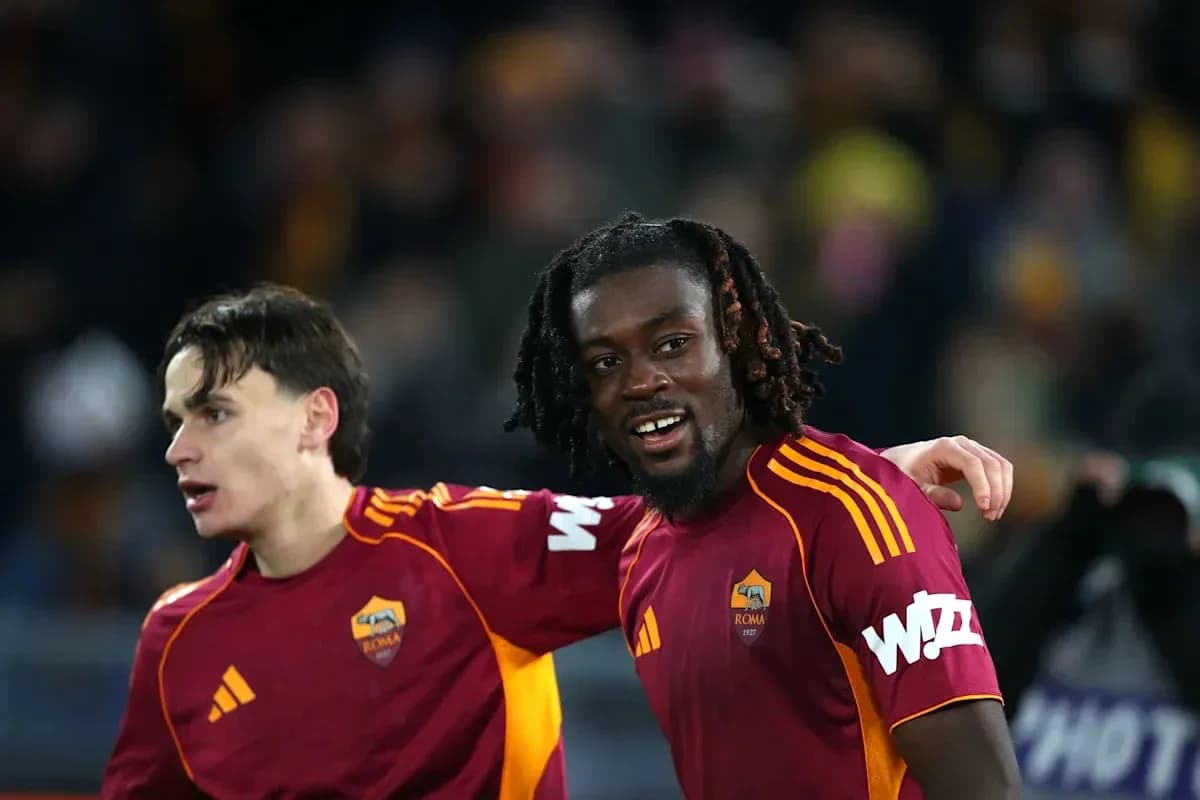 Dos jugadores de la Roma posando sonrientes en el campo