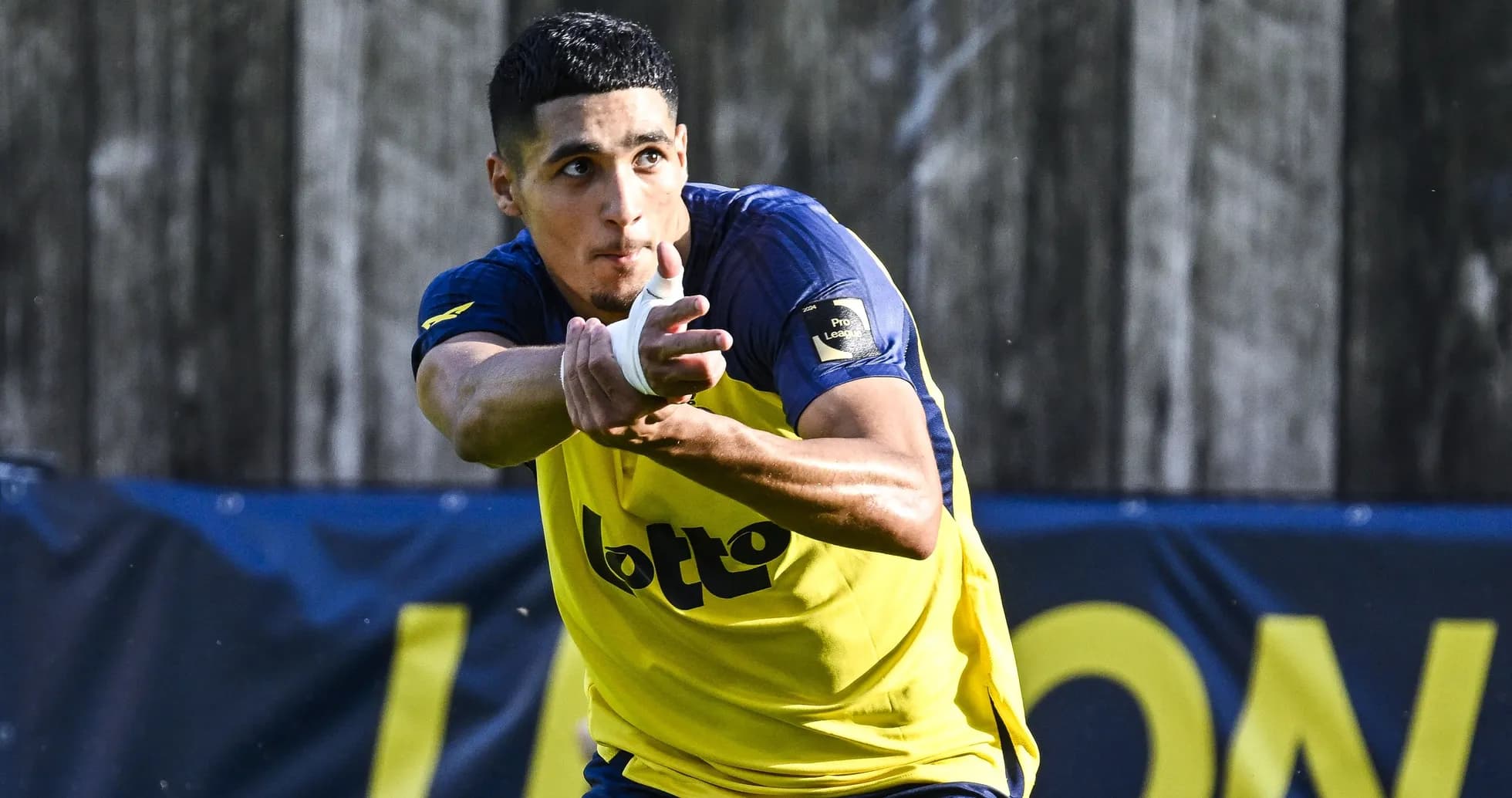 Jugador entrenando con balón en campo de fútbol