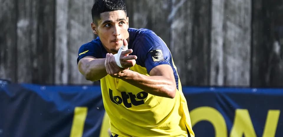 Jugador entrenando con balón en campo de fútbol