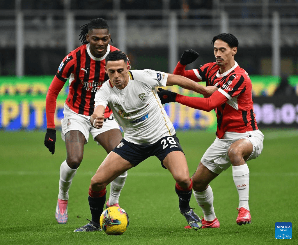 Jugadores de AC Milan y Cagliari luchando por el balón