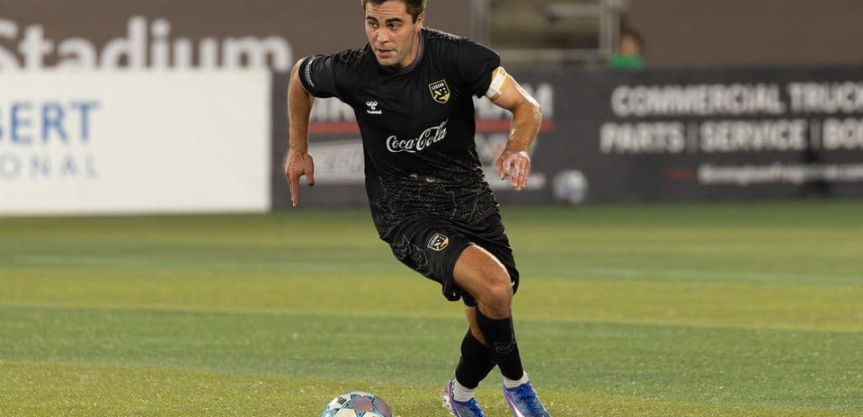 Jugador corriendo tras el balón en el campo