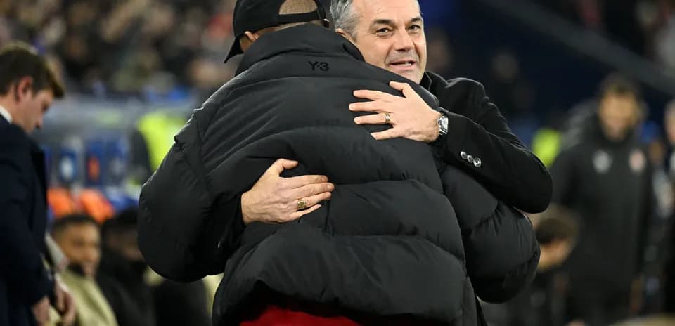 Entrenadores abrazándose en el banquillo durante partido