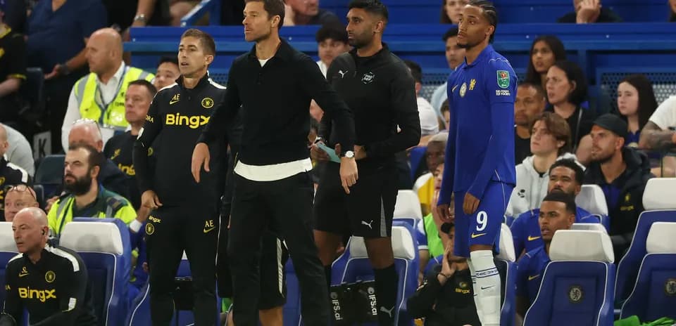 Entrenadores y jugadores en la banca durante el partido